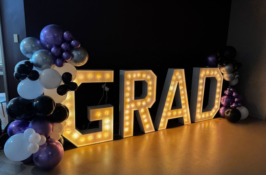 Balloon decor and marquee letters that spell out "Grad"