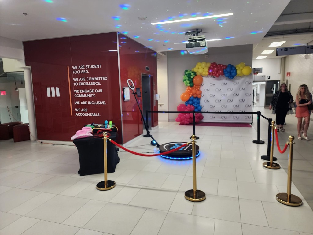 360 video booth with corporate backdrop and balloon decor